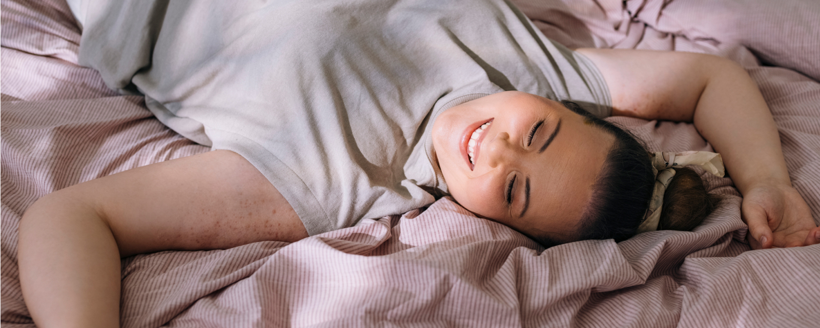 A birthing parent smiling and resting at home after delivery